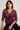 Woman wearing a patterned blouse against a plain background