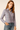 Woman wearing a plaid shirt and jeans on a beige background