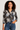 Woman wearing a floral blouse and jeans on a plain background