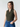 Woman wearing a green sleeveless top and blue jeans against a plain background
