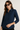 Woman wearing a navy blue patterned shirt against a plain background