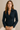 Woman wearing a navy blue blazer against a beige background