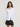 Woman wearing a white shirt and black leather skirt on a plain background