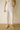 Person wearing white M&S - Per Una pants and a beige top and beige flats