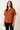 Woman wearing a brown button-up shirt with short sleeves on a beige background