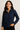 Woman wearing a navy blue shirt against a plain background