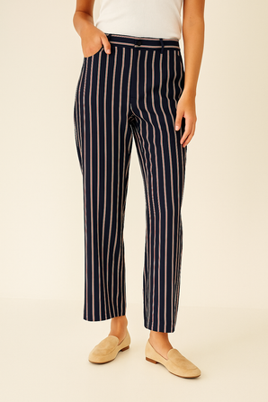 Person wearing navy and beige striped pants and beige flats 