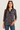 Woman wearing a patterned top with a plain background