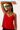 Woman wearing a red top and sunglasses against a plain background