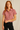 Woman wearing a red and white striped shirt against a beige background